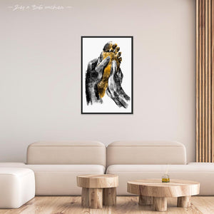 Mock up of 24x36 inches black framed poster depicting a foot massage. Two black hands massaging a warm and yellow foot in a realistic carbon style. From the Healing Hands collection.